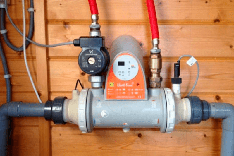 Echangeur pour chauffer une piscine devant un mur en bois.