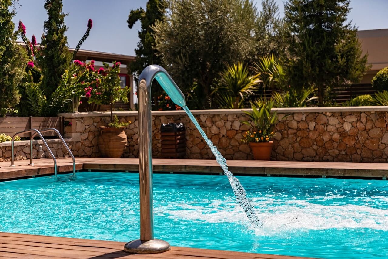 Piscine avec un buse et un mur en pierres sèches.